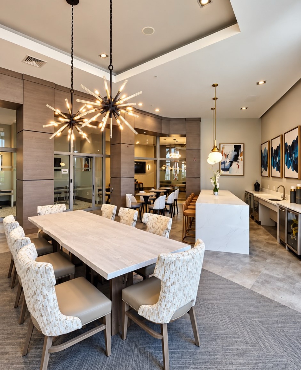 Commercial dining lounge with statement chandeliers and a white island